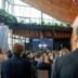 Audience seated in a modern atrium-style conference hall watching a stage presentation with a large screen that reads FutureLAW '26 and hosts on stage.